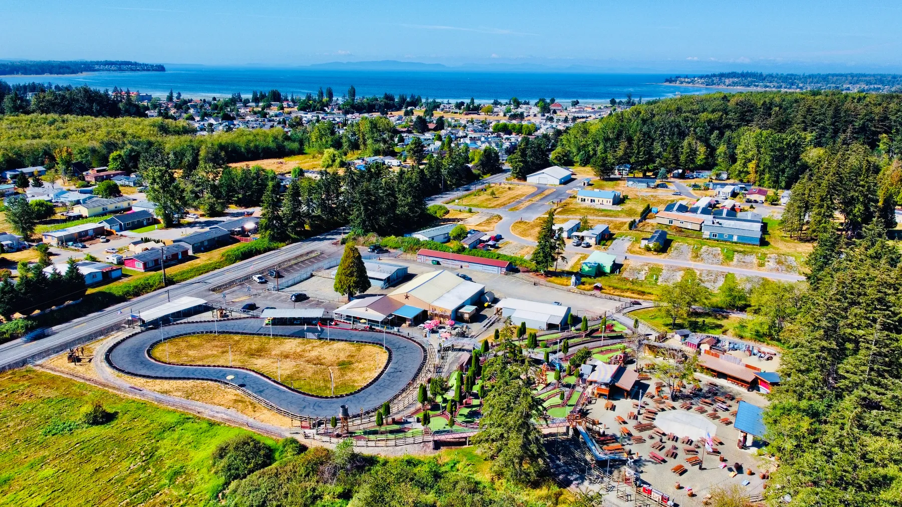 Aerial view of Station 49 in Birch Bay, WA — the go-kart track, mini golf, and picnic grounds with the bay in the background