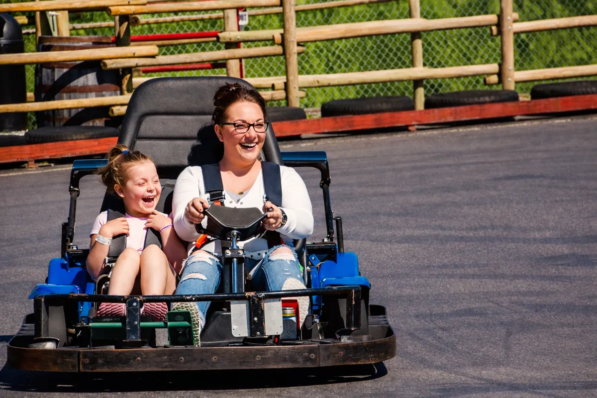 A parent and child riding a go-kart together